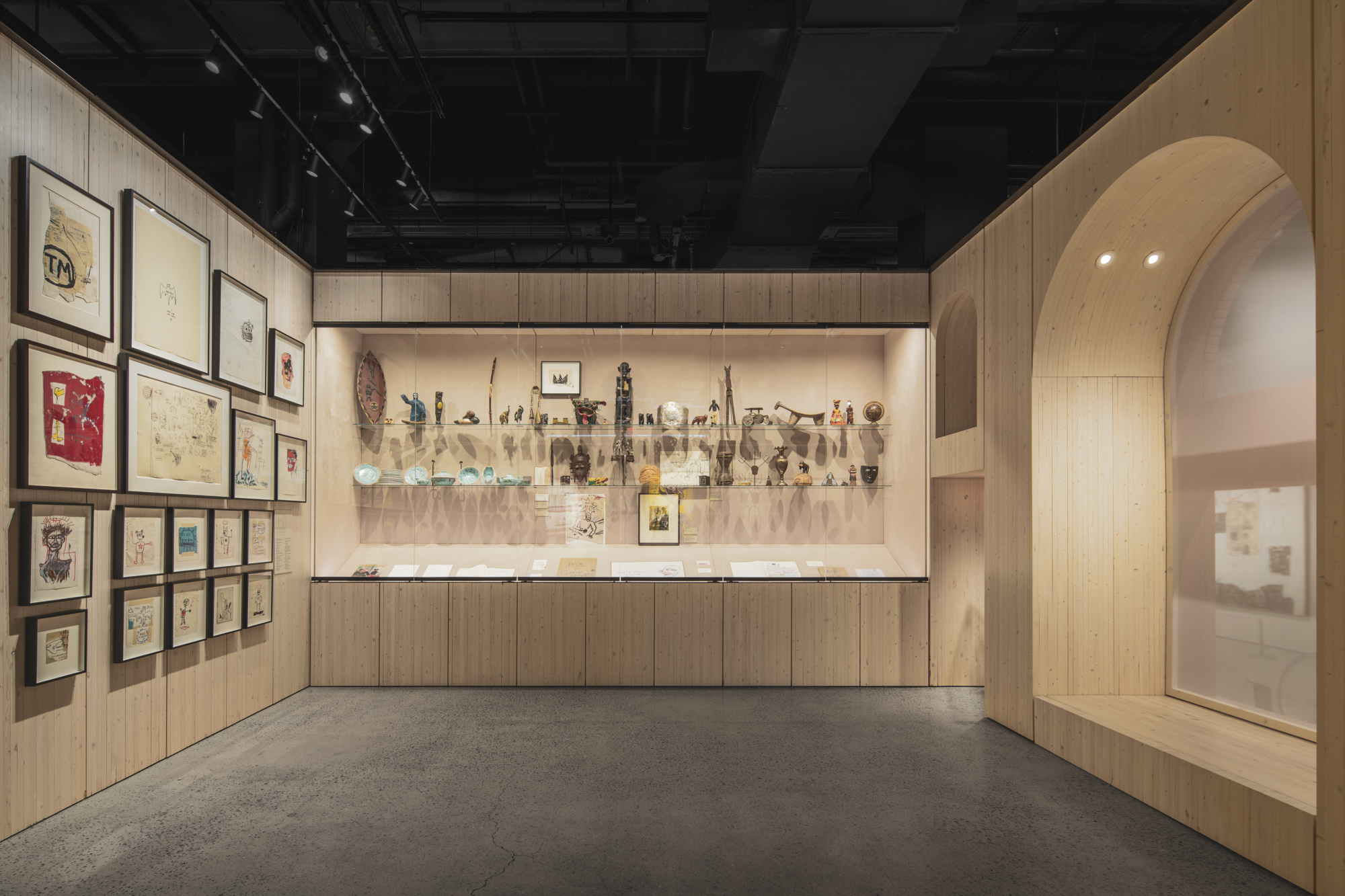 Exhibition view of Jean-Michel Basquiat works showing his distinctive style of crowns, skulls, and text